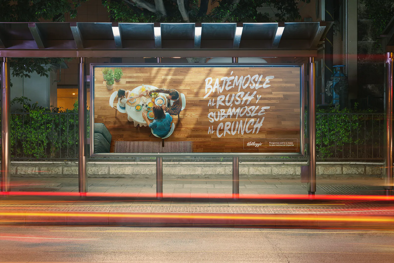 Aplicación OOH de la campaña Kellogg's de Follow Me Agency: paradero de noche con el afiche Bajémosle al rush y subámosle al crunch